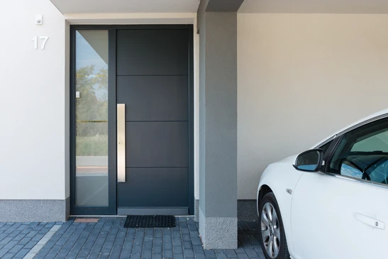 Entrée moderne d'une maison contemporaine avec porte d'entrée anthracite et panneau vitré latéral